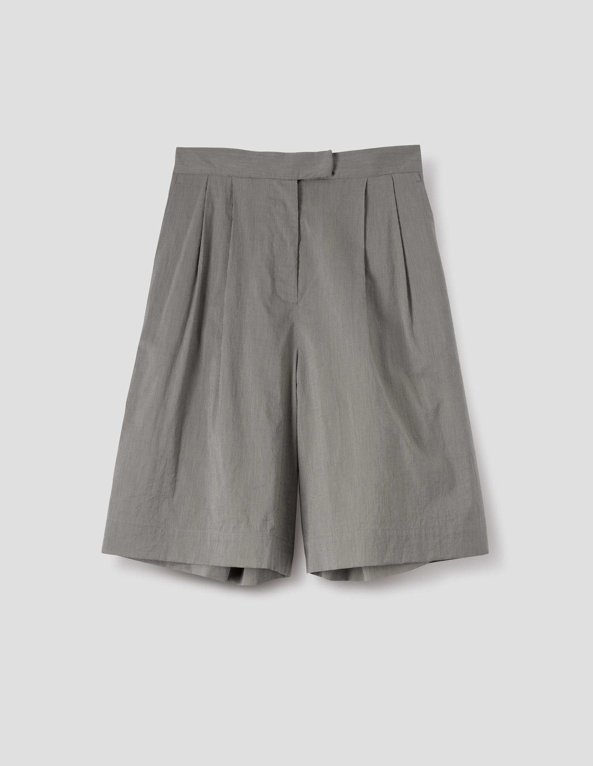Black and cream stripe long shorts with double pleats, hook and bar tab fastening waistband, zip fly and slant side pockets. Front flat lay view. 