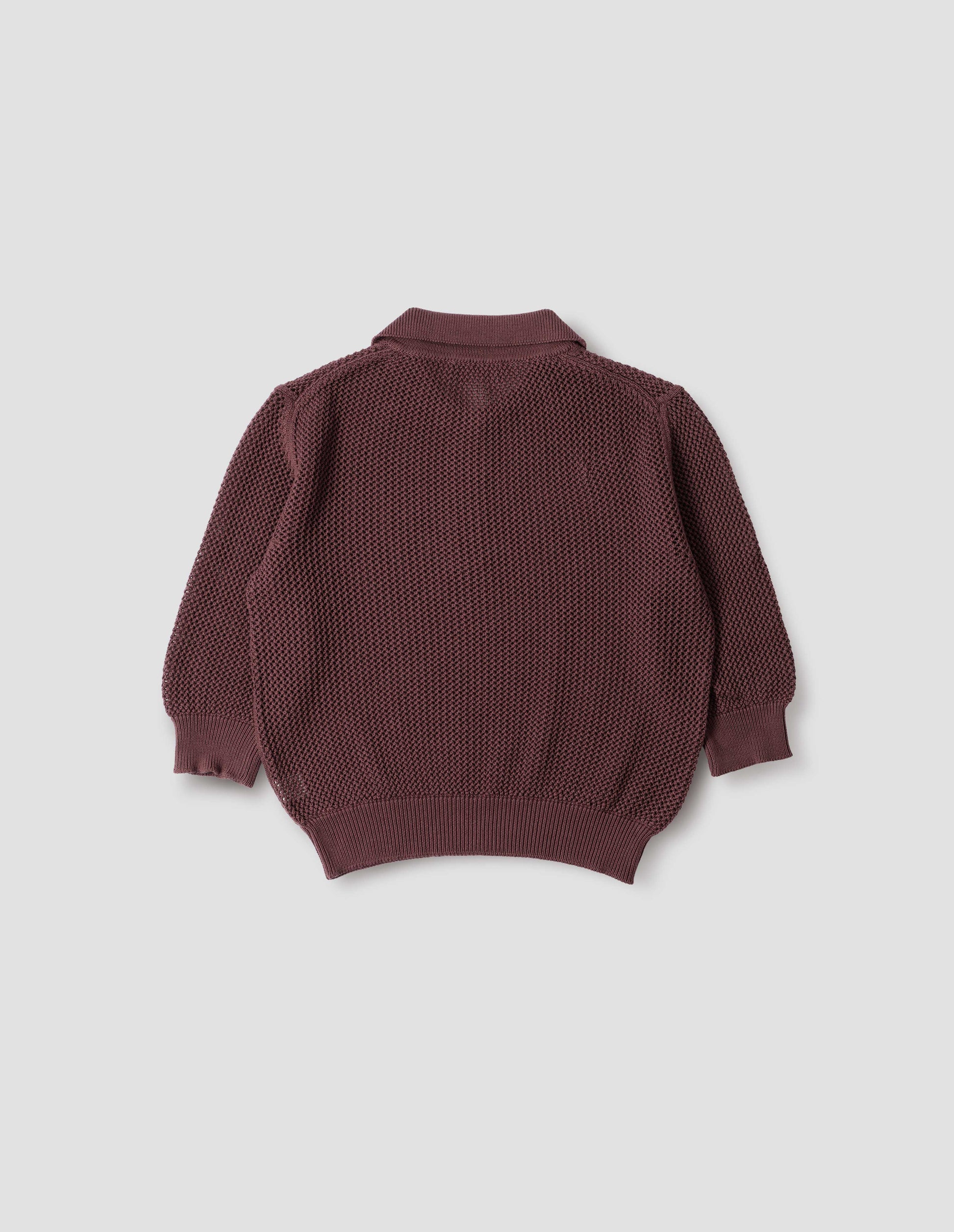 Brownish red cotton cashmere pointelle polo shirt, with solid seam detailing, rib collar, placket, cuffs and hem. Back flat lay view.