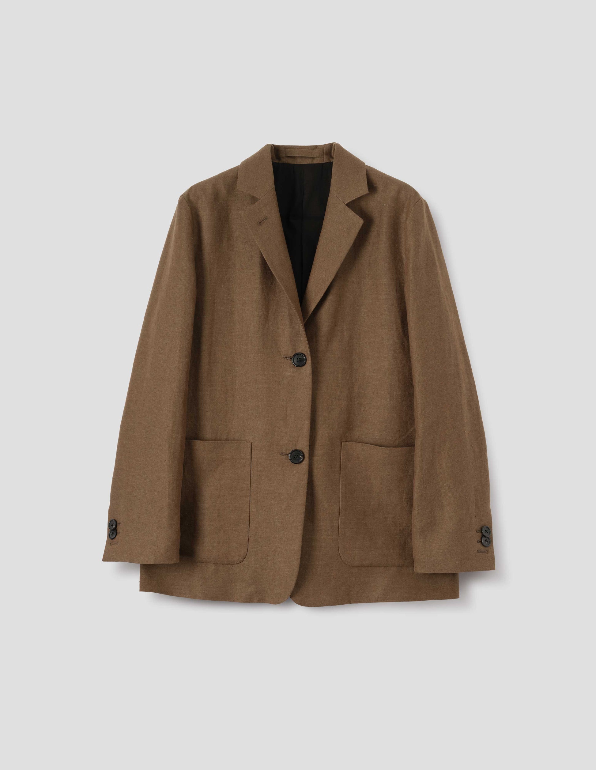 Brown blazer with dropped shoulders, large patch pockets and horn button closure and cuffs. Front flat lay view.