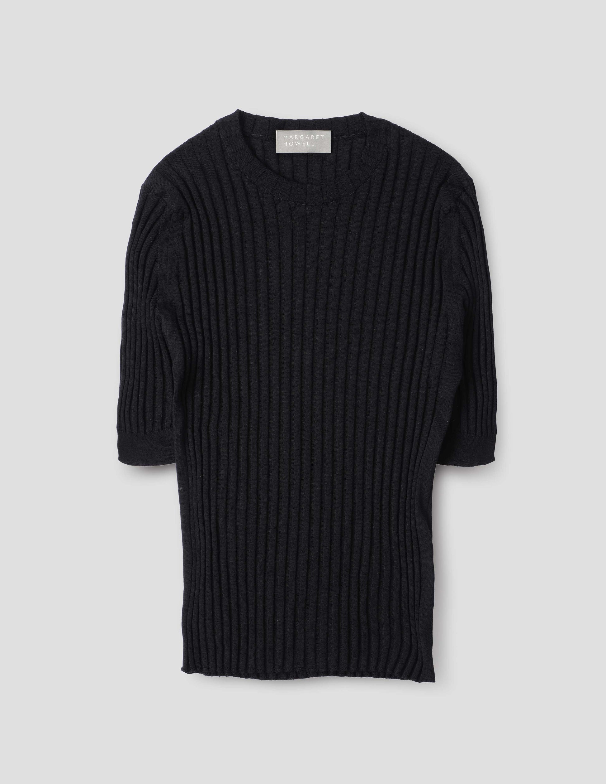 Black knitted ribbed t-shirt with round neck and fine rib sleeve cuffs. Front flat lay view.