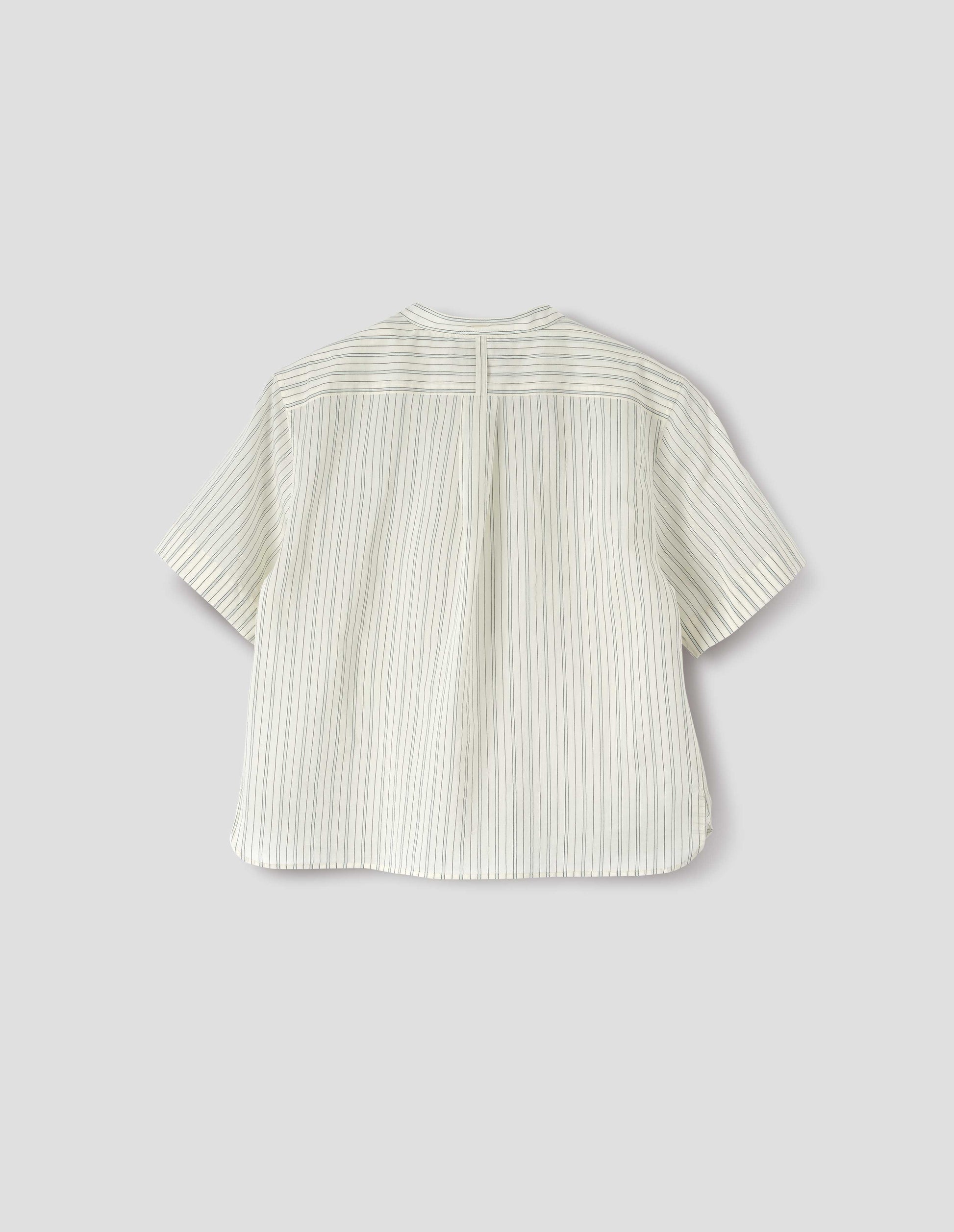 Striped beige and light blue collarless shirt with short sleeves, side split stepped hem, box pleat and hanger loop detail on back yoke, and buttonhole detailing on collar band. Back flat lay view.