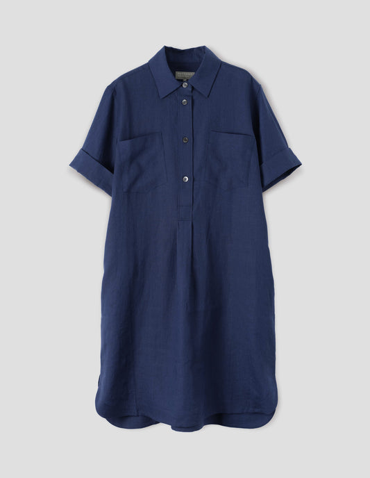 Blue linen shirt dress, with raised stitch placket, concealed side pockets, two patch chest pockets and mother of pearl buttons. Front flat lay view.