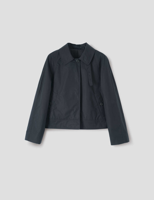Black ventile cotton poplin long sleeve short trench, with horn button closure, slant side pockets, adjustable storm tab and hanger loop on collar, front flat lay view. 