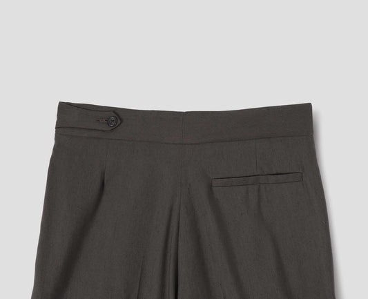 Greenish brown linen silk trousers with pull through double tab side fastening and back pocket, back flat lay view.