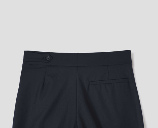 Dark navy summer wool trousers with pull through double tab side fastening and back pocket, back flat lay view.