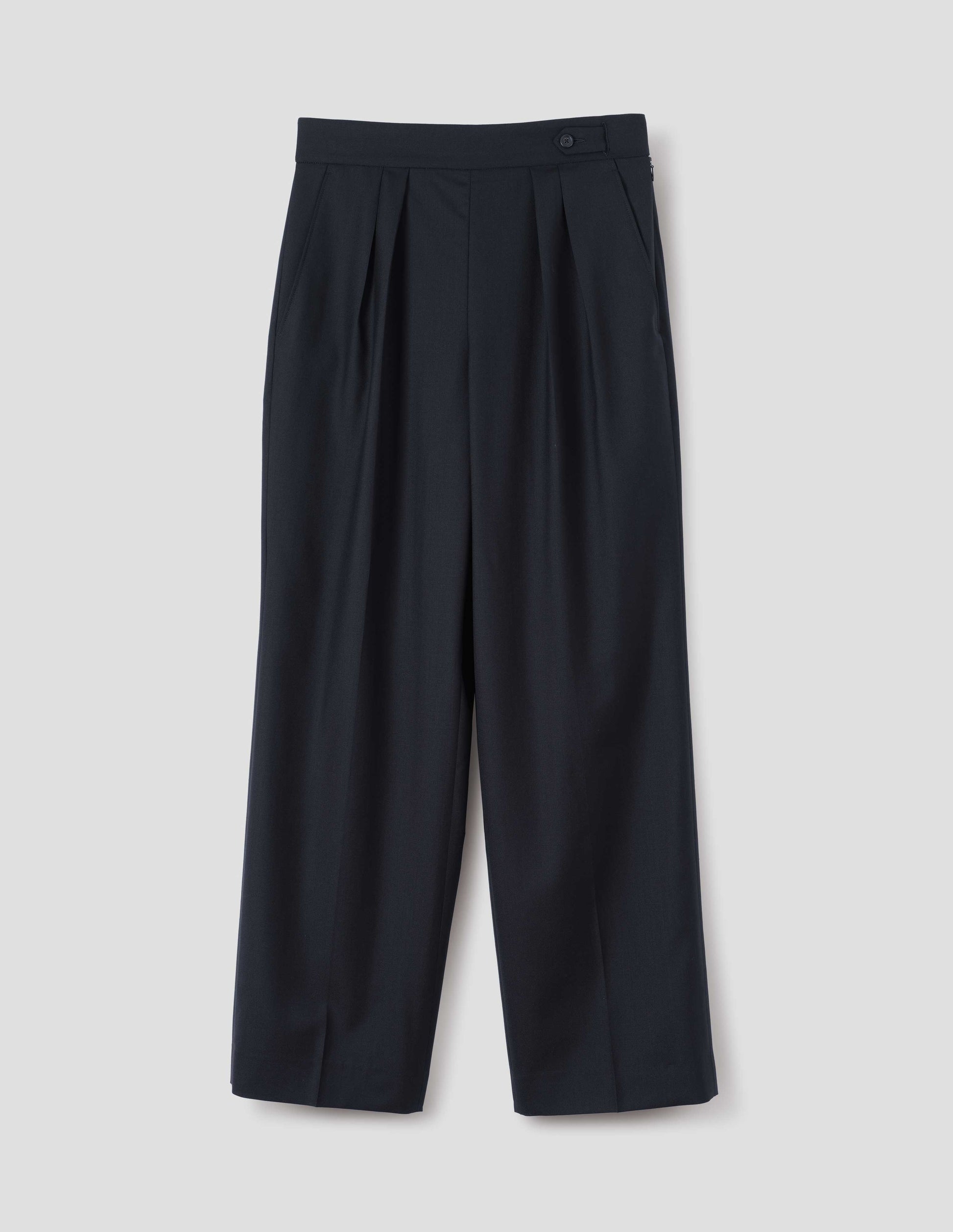 Dark navy summer wool trousers with double pleats, concealed side zip, pull through double tab side fastening and slant side pockets, front flat lay view.