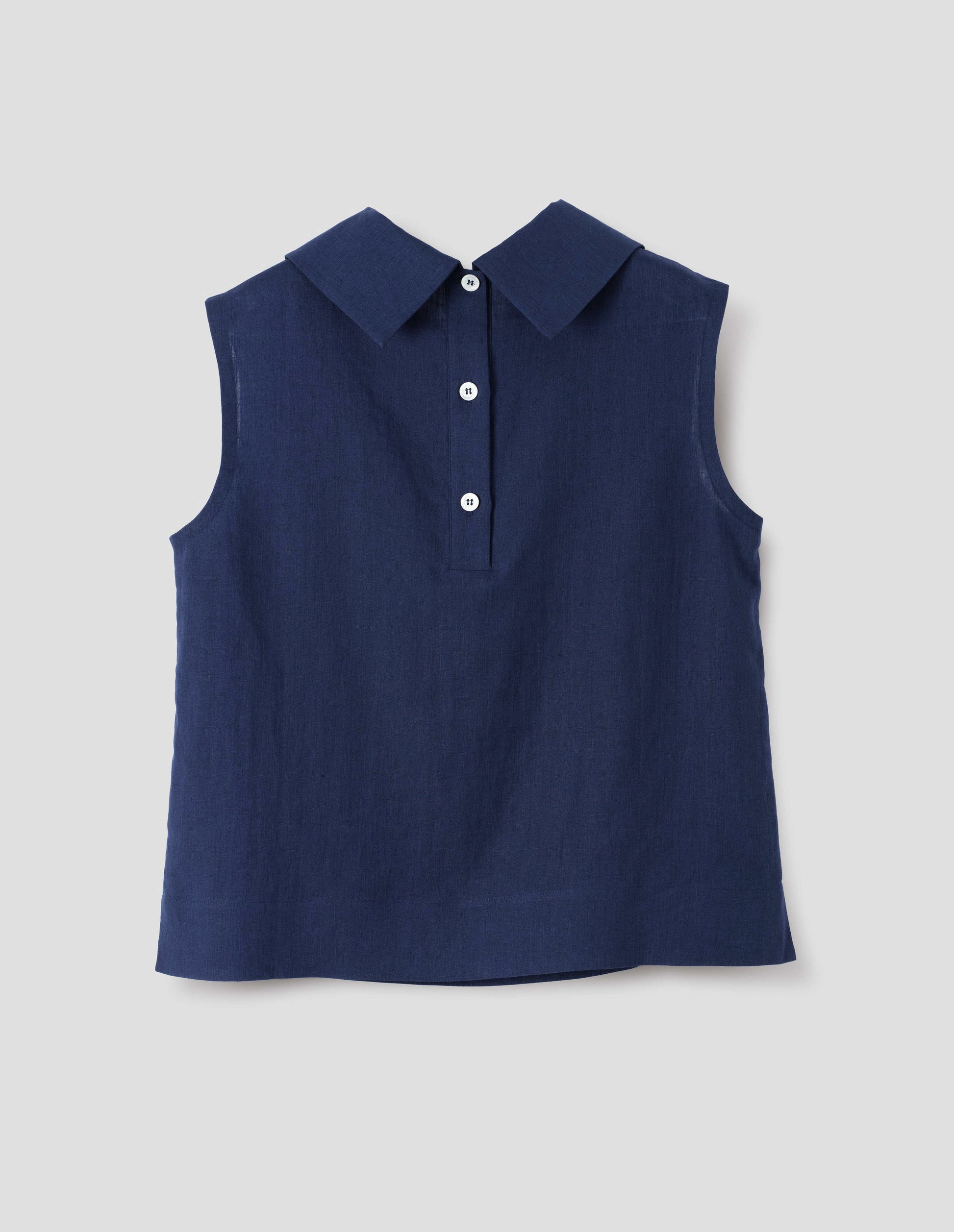 Dark blue regular cut Irish linen top with exaggerated collar, button-fastening placket at the centre back, with a deep hem with side splits. Back flat lay view.