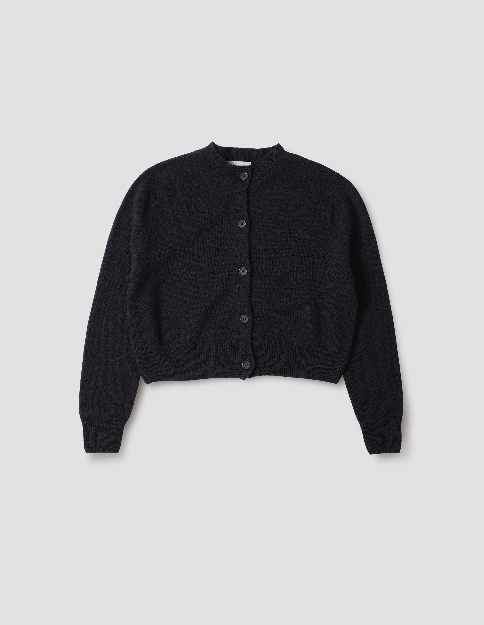 Dark navy  long sleeve merino cashmere cardigan with contrast rib neckline, cuffs and hem and dark horn buttons. Front flat lay view.