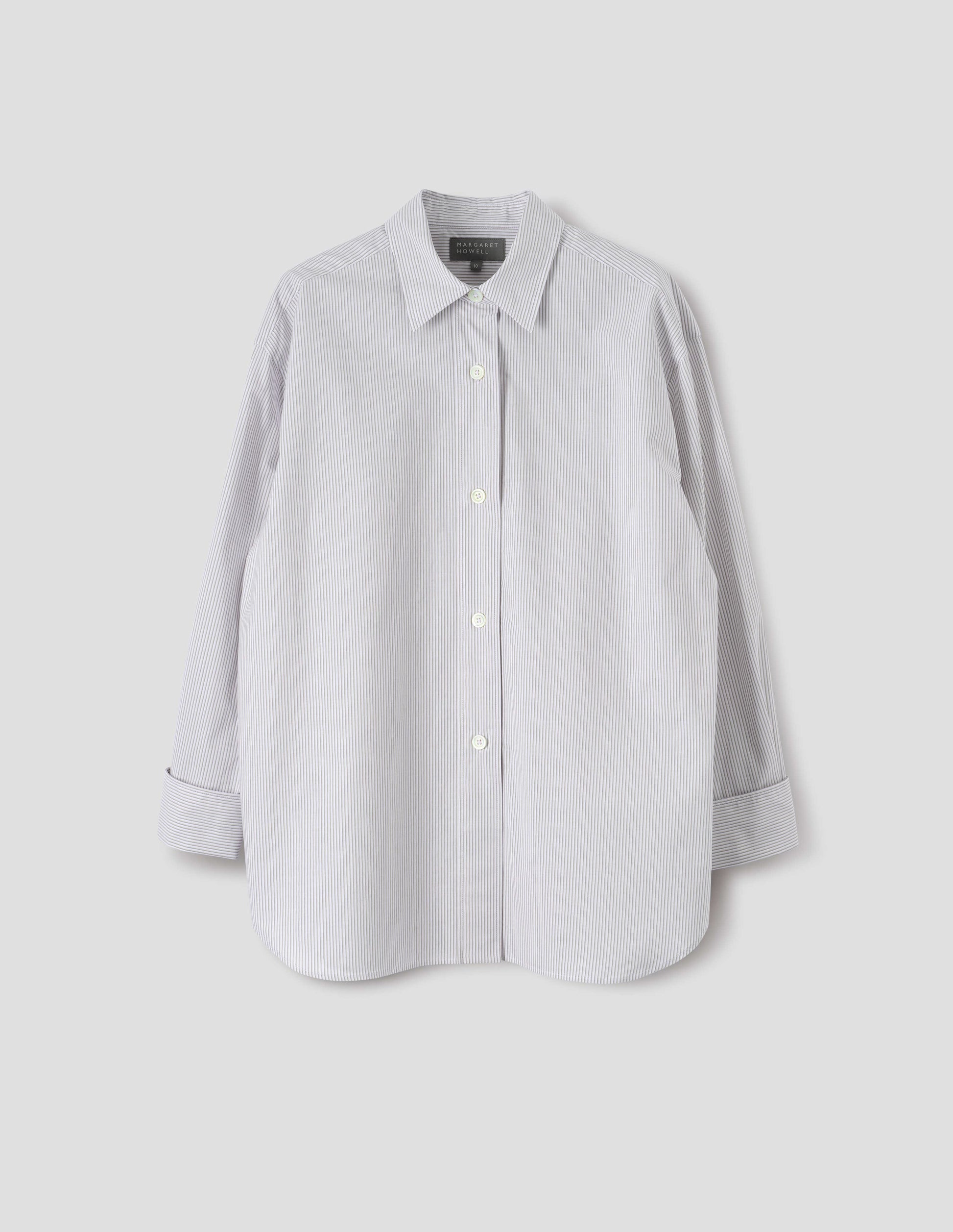 White and grey stripe relaxed cut and dropped shoulder cotton shirt, with collar, wide, raised placket and turned back double cuffs. Front flat lay view.