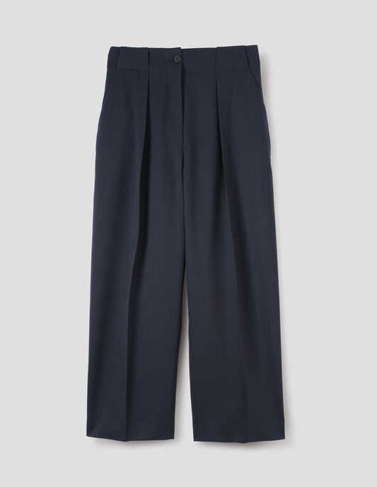 Dark navy wool trousers, single pleats and grown-on waistband with large belt loops and horn button. Front flat lay view.