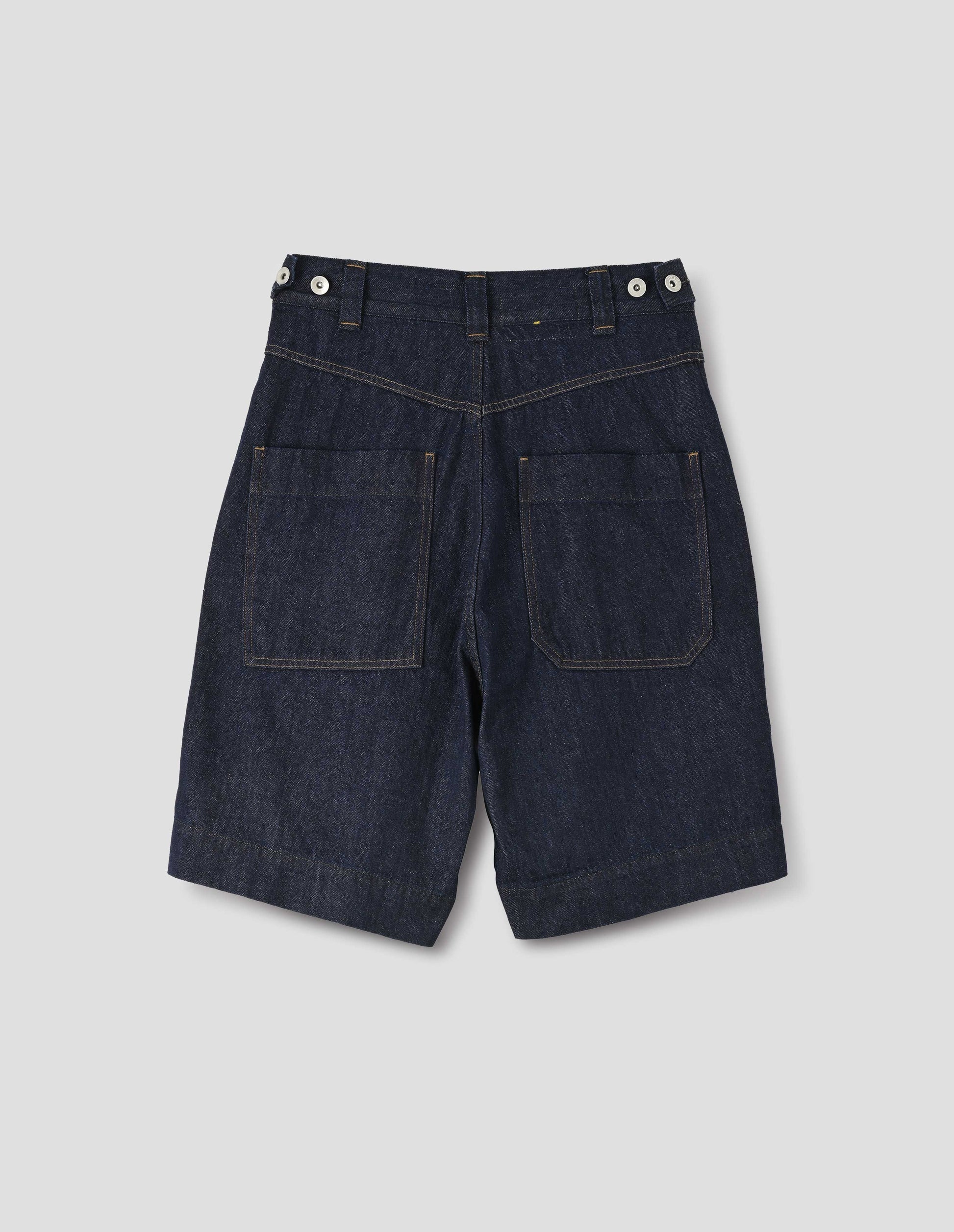 Dark blue denim twill shorts. With metal button tab waist adjusters, belt loops and patch pockets. Back flay lay view.