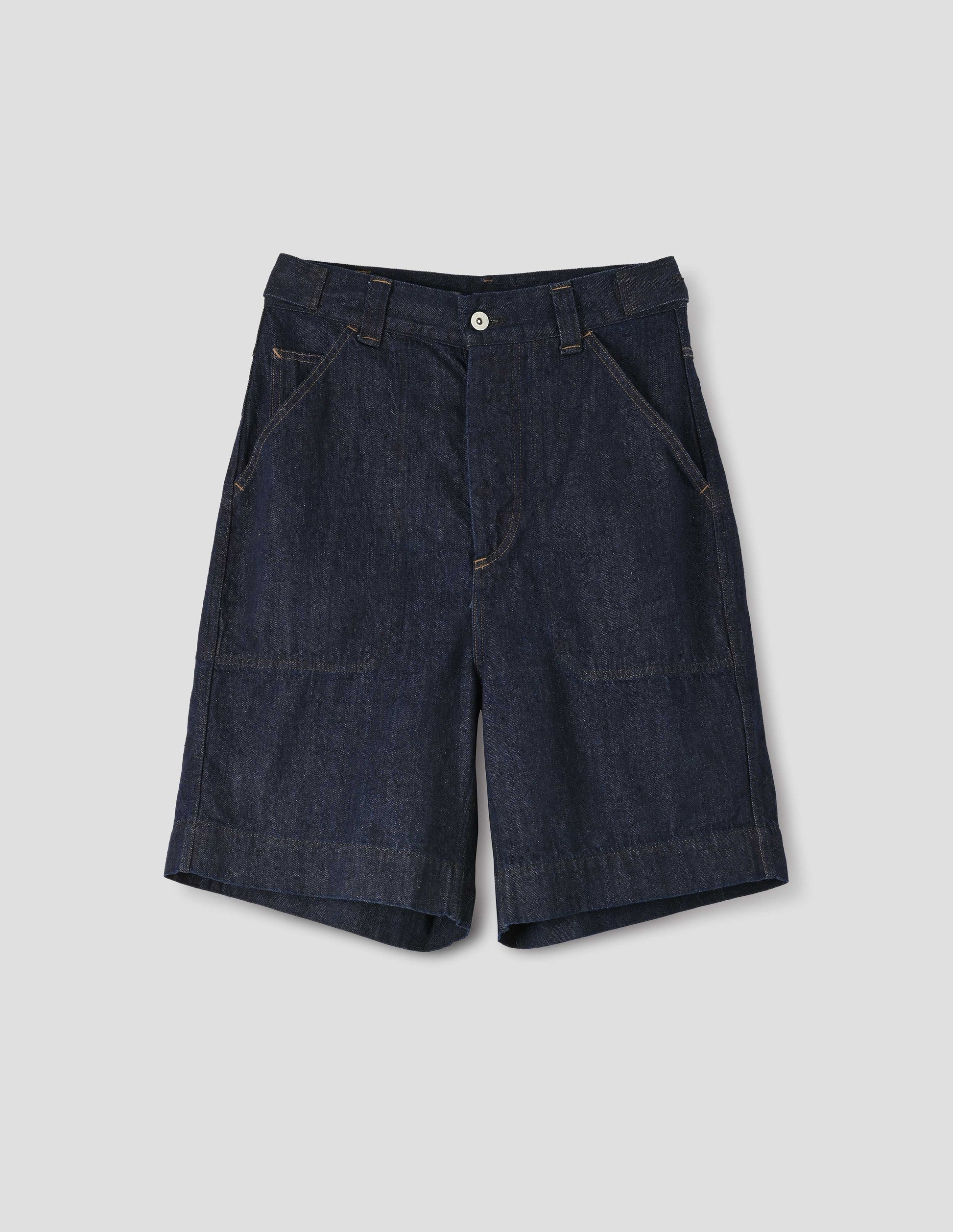 Dark blue denim twill shorts. With metal button tab waist adjusters, metal button fly, belt loops and slant stitch-through pockets with ticket pocket detail. Front flay lay view.
