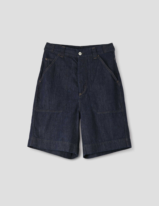 Dark blue denim twill shorts. With metal button tab waist adjusters, metal button fly, belt loops and slant stitch-through pockets with ticket pocket detail. Front flay lay view.