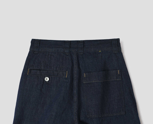 Dark blue denim twill trousers with high waist, belt loops, metal button-through welt and patch back pocket. Back flat lay view. 