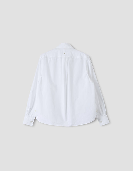 White regular cut shirt with box pleat on back yoke, corozo button cuffs and curved hem. Back flat lay view. 