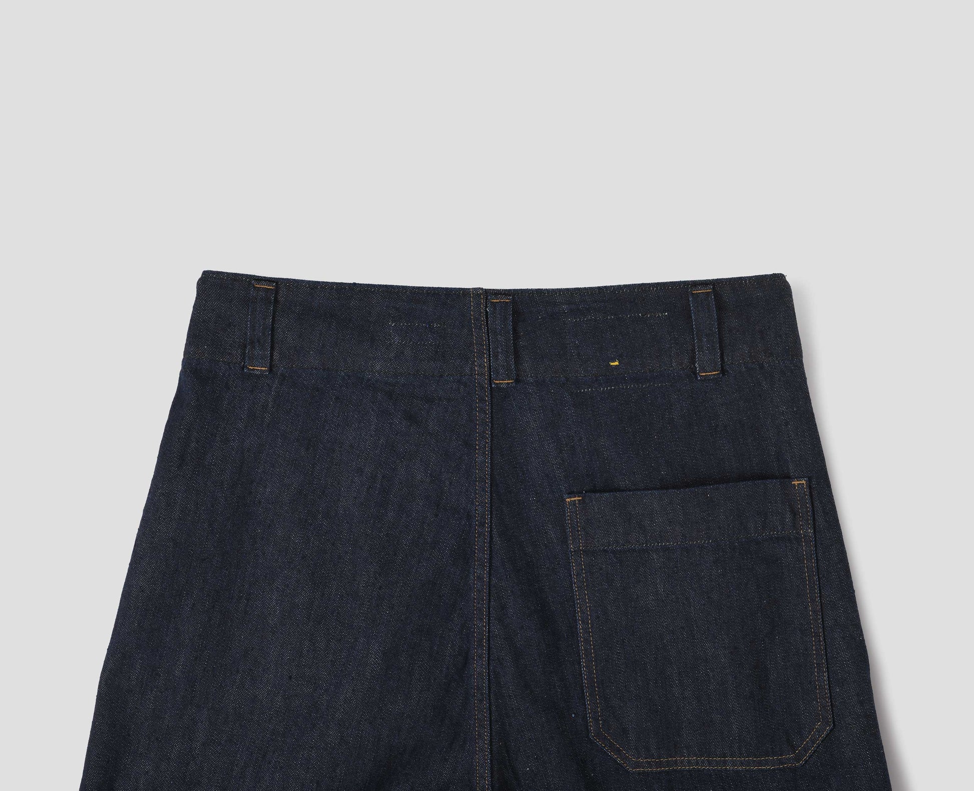 Indigo blue wide leg light denim twill jean, with slant side pockets, patch back pocket and belt loops. Back flat lay view.