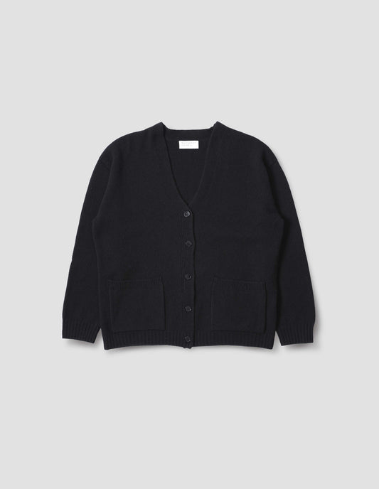 Black merino cashmere bed cardigan, with contrast rib on neck, cuff and hem and front patch pockets. Front flat lay view.