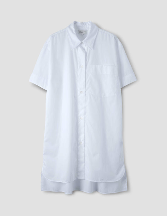 White lightweight cotton short sleeve nightshirt with mother of pearl buttons, patch pocket and side split hem with longer back. Front flat lay view.